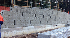 Construction of segmental block wall facing attached to earth anchors